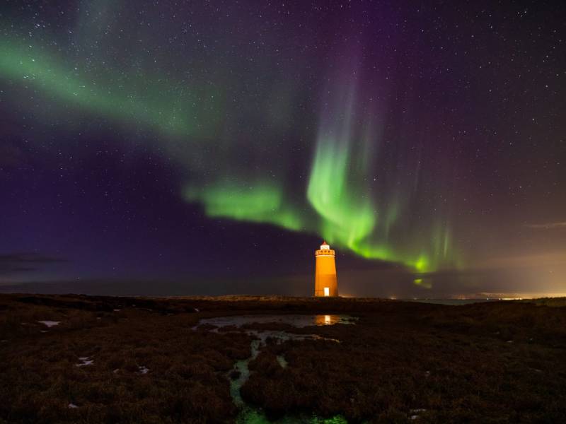 Lighthouse on Reykjanes peninsula under nortern lights. Iceland
